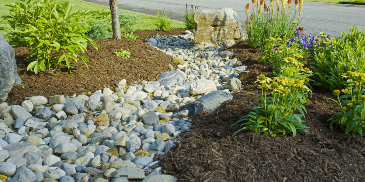 river rock, mulch and plants in lawn