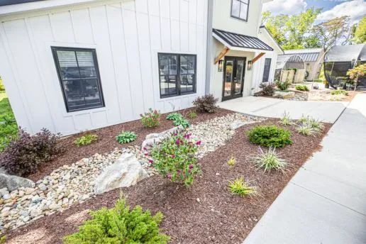 plant-design Front view of landscaping done with mulch, plants, a gravel walkway