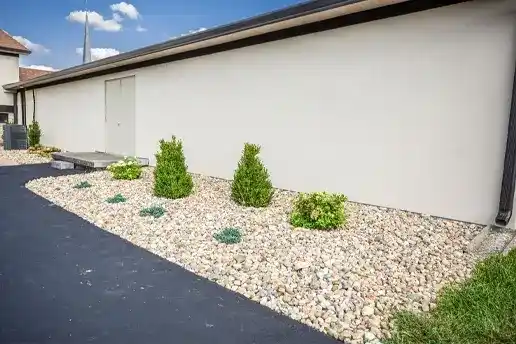 Front view of landscaping done with mulch, plants, a gravel walkway